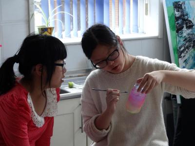 chinese girls painting during an art activity at english summer school in england